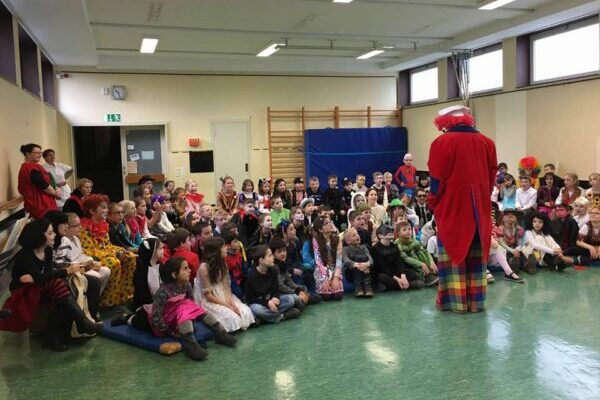 Clown unterhält Kindergruppe bei Firmenevent